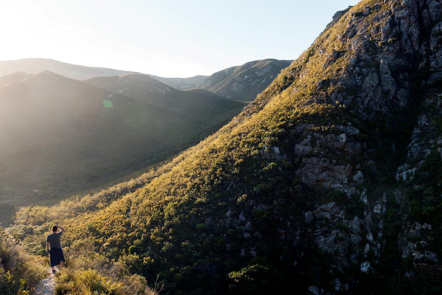 Wanderer auf einem Bergpfad blickt auf den Sonnenaufgang.